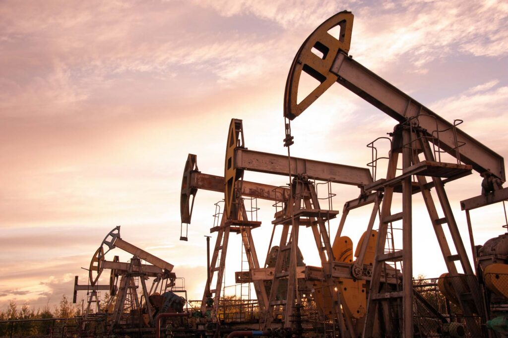Oil pump jacks at sunset sky background